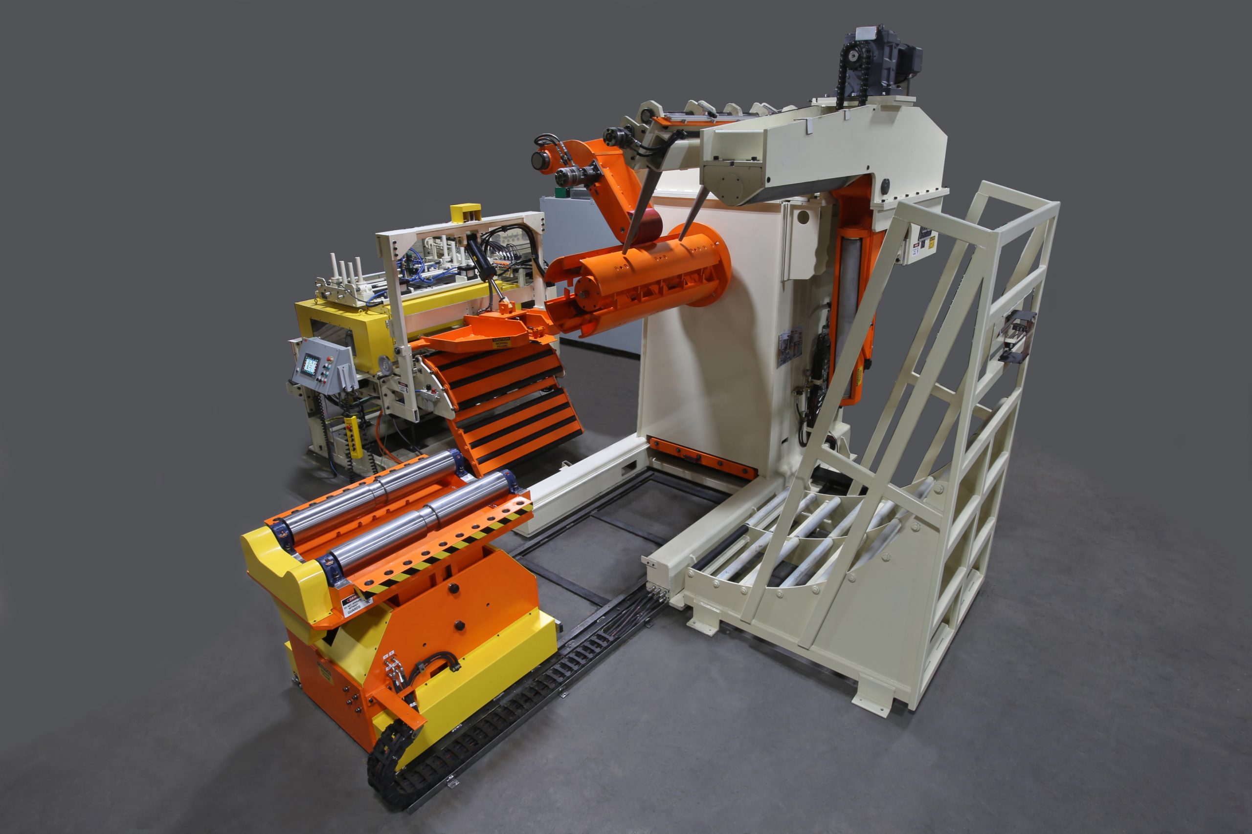 Línea de alimentación que ahorra espacio de Colt Automation con carro de bobinas móvil, mandril de dientes de sierra, brazo de sujeción y enderezadora motorizada para el procesamiento de bobinas de acero.